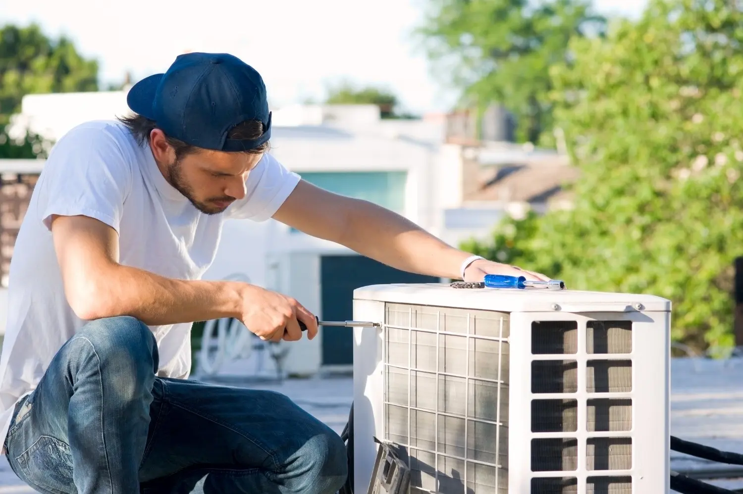 Man repairs heat pump on roof.