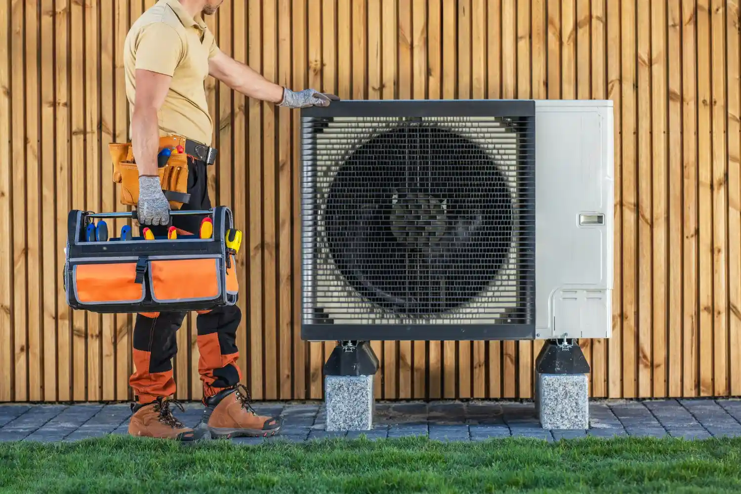 Technician with toolbox near heat pump.