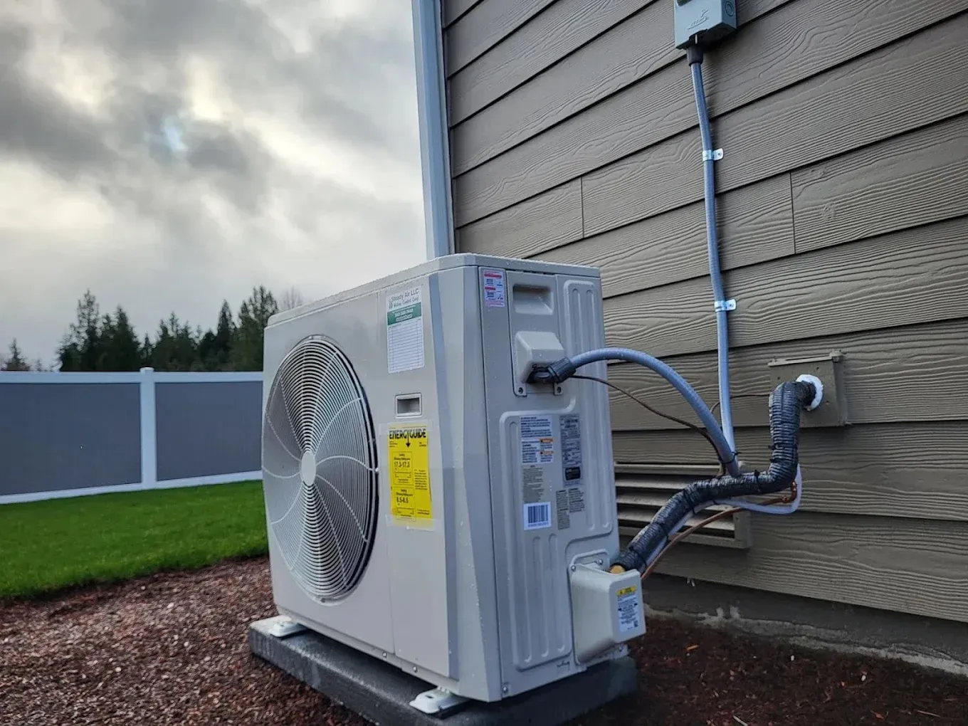 Top Benefits of Ductless Mini-Split Systems 3 Technician performing maintenance on a ductless mini-split system outdoors, highlighting the importance of professional installation